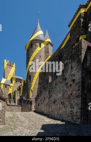 Carcassona, Languedoc, Francia; 23 luglio 2018: Porta Aude della città medievale di Carcassona con la decorazione di cerchi gialli di Felice Varini Foto Stock