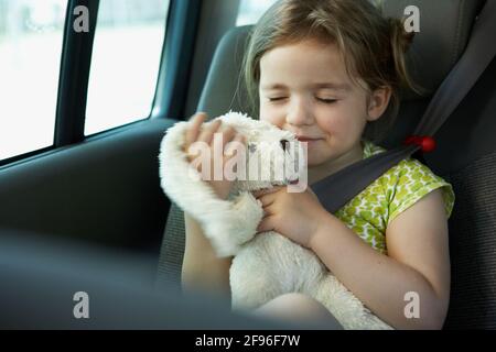 Ragazza con peluche giocattolo nel sedile dell'auto Foto Stock