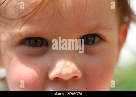 Piccolo bambino grigio-eyed. Primo piano della foto Foto Stock