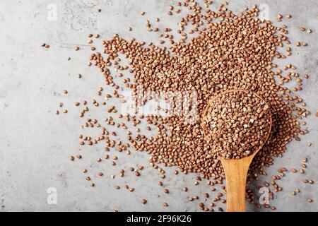 Grano saraceno grezzo in un cucchiaio di legno. Grani interi organici. Foto Stock