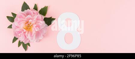 International Women's Day Concept, banner. Layout realizzato con il numero otto e fiore di pony su sfondo rosa. Spazio di copia. Disposizione piatta. Foto Stock