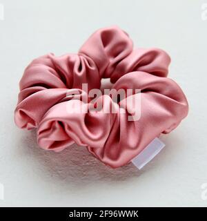 Seta rosa Scroccante isolato su sfondo bianco. Accessorio per capelli piatto di fascia elastica colorata per capelli, Bobble Scrunchie Hairband Foto Stock