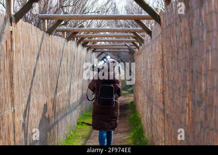 Il fotografo di uccelli camminando in un sentiero e di ritorno a. la casa Foto Stock