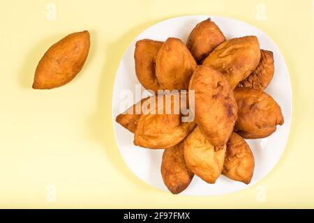 Mazzette ripiene fritte in piatto giallo su sfondo giallo naturale con spazio per la copia. Foto Stock