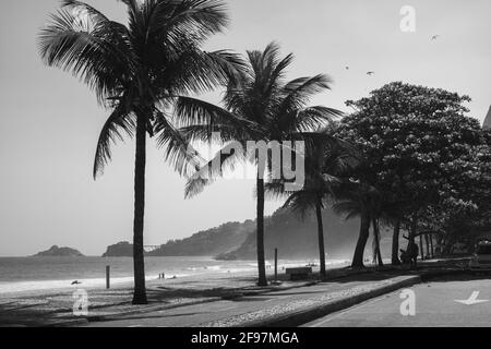 Leblon lungomare vicino a Ipanema con palme e Morro dois Iramaos (due fratelli montagna) in background a Rio de Janeiro, Brasile. Girato in bianco e nero con Leica M10 Foto Stock