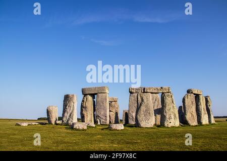 Antica Stonehenge - rocce in piedi - in Gran Bretagna sotto un bel cielo blu in una giornata di sole con contrasto ombre Foto Stock