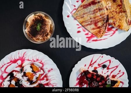 Colpo d'asta di vari dessert deliziosi su sfondo nero Foto Stock