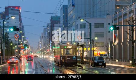 Hiroshima strade con traffico auto e tram in primo piano Foto Stock