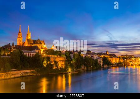 Vista al tramonto sul fiume Reno a Basilea, dominato dal maestoso edificio della chiesa di Munster, in Svizzera Foto Stock