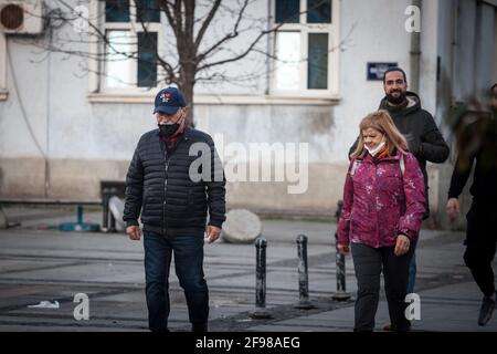 BELGRADO, SERBIA - 21 FEBBRAIO 2021: Anziano che indossa una maschera respiratoria sotto il naso che cammina in una strada di Belgrado, durante la corona Foto Stock