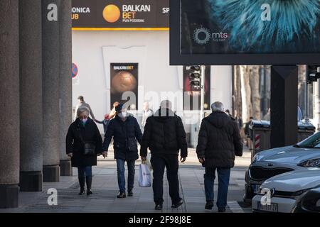 BELGRADO, SERBIA - 21 FEBBRAIO 2021: Sfocatura selettiva sull'anziano uomo e sulla donna, coppia, indossando una maschera facciale, svegliandosi in una strada di Belgrado in vino Foto Stock
