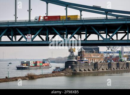 Krefeld, Renania Settentrionale-Vestfalia, Germania - il Rheinhafen Krefeld è il quarto porto più grande della Renania Settentrionale-Vestfalia, una nave container passa oltre il terminal dei container KCT Krefelder, di fronte a un camion che guida sul ponte Krefeld-Uerdinger sul Reno. Foto Stock