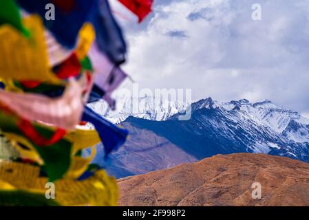Bandiere di preghiera colorate che volano in venti con le montagne di Himalaya al villaggio di Komic della Valle di Spiti, Himachal Pradesh, India. Foto Stock