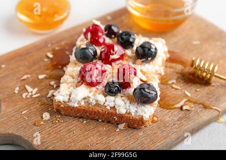 Gustosi panini con formaggio casolare e frutti di bosco su tavola di legno Foto Stock