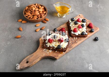 Panini con formaggio di cottage, mirtilli e lamponi su sfondo grunge Foto Stock