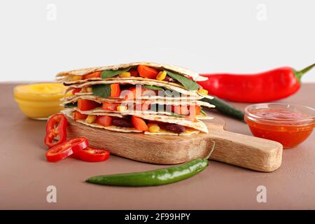 A tavola con gustose quesadillas vegetariane, salse e verdure sul tavolo Foto Stock