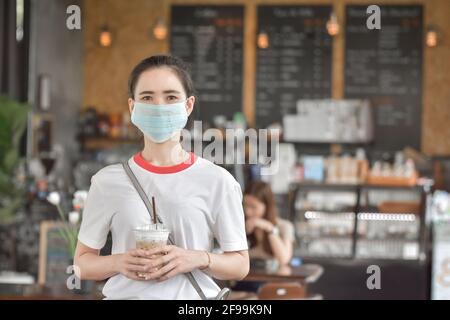 Le donne asiatiche indossano la maschera facciale nel caffè, le donne asiatiche indossano la maschera proteggono il cavid19 del coronavirus Foto Stock