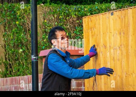 Un uomo che installa la recinzione di sicurezza presso la residenza ufficiale dell'ambasciatore del Myanmar nel Regno Unito. Foto Stock