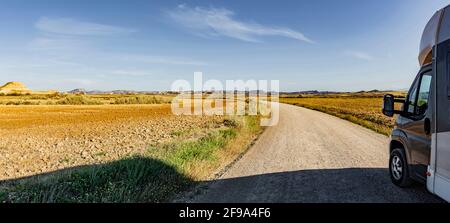 Motorhome su una strada di polvere in un paesaggio desertico Foto Stock