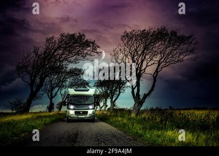 Motorhome su una stretta strada di campagna con alberi Foto Stock