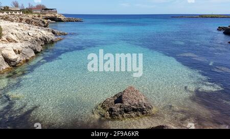 Costa rocciosa del Mar Ionio nel villaggio di Ognina, vicino alla provincia di Siracusa in Sicilia Foto Stock