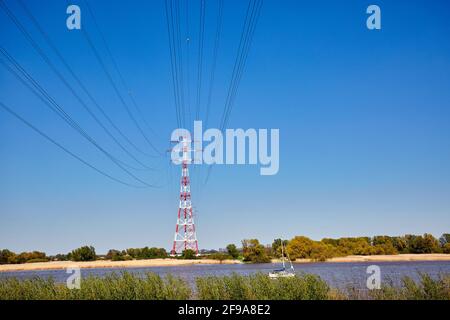 Germania, Amburgo, piloni elettrici rossi e bianchi sotto un cielo blu Foto Stock