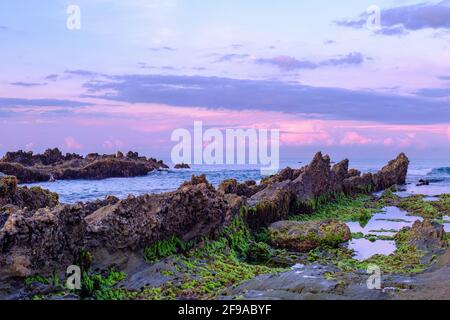 Vista della roccia sul bordo della spiaggia di Sawarna al mattino. La posizione di questa spiaggia è nella provincia di Banten, Indonesia Foto Stock