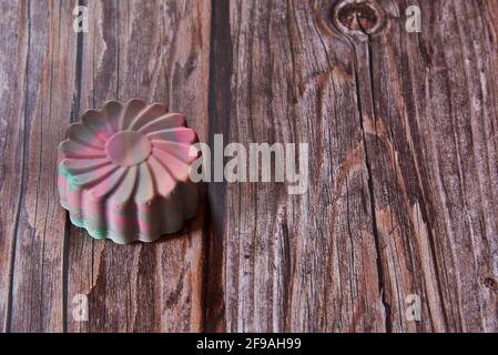 Sapone organico brillante fatto a mano profumato a forma di fiore su fondo di legno. Foto Stock