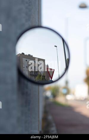 Vista di uno specchio circolare su una recinzione metallica, Reggio Emilia. Italia Foto Stock