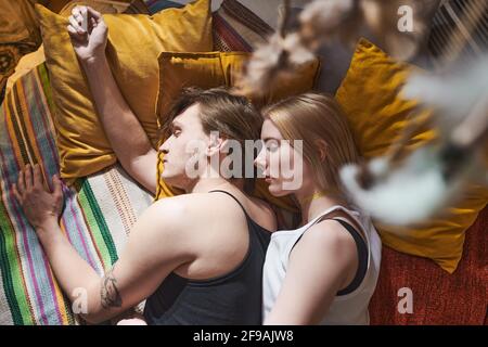 Vista ad alto angolo di una giovane coppia che dorme in un abbraccio il letto nella loro camera da letto Foto Stock