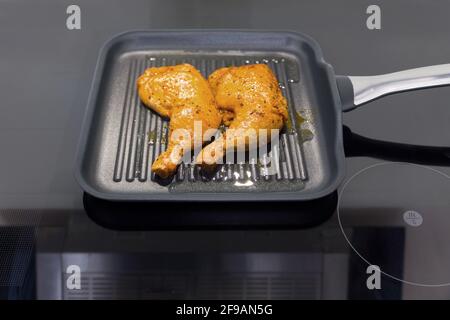 Due cosce di pollo in una padella Foto Stock