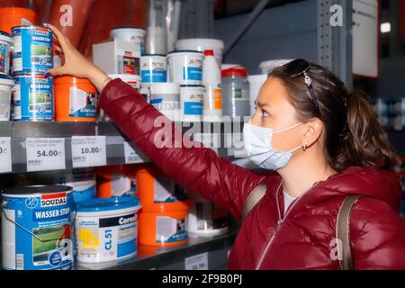 Batumi, Georgia - 15 marzo 2021: Ragazza in un negozio di hardware sceglie in vernice Foto Stock