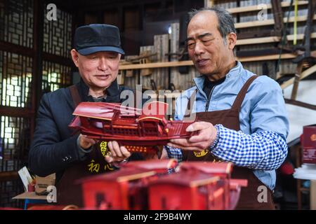 (210417) -- HANGZHOU, 17 aprile 2021 (Xinhua) -- Han Minghua (L) controlla un modello di barca rossa al laboratorio di Jiaxing Minghua Ship Model Manufacturing Co., Ltd. A Yuxin Città di Jiaxing City, Provincia di Zhejiang della Cina orientale, 13 aprile 2021. Sul lago Nanhu a Zhejiang riposa una delle barche più famose del paese -- la barca rossa. Ogni giorno, molti visitatori si accodano per rendere omaggio alla storica barca, che onora la conclusione del primo Congresso Nazionale del Partito Comunista Cinese (CPC) nel 1921. In occasione del centesimo anniversario del CPC, Han Minghua, ereditatore del modello Red Boat ma Foto Stock