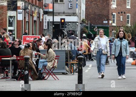 Manchester, Regno Unito. 16 Apr 2021. La gente apprezza il caldo in Stevenson Square a Manchester. I pub e i ristoranti con spazio all'aperto sono stati autorizzati a riaprire, in quanto le restrizioni di blocco sono attenuate nel Regno Unito. Credit: SOPA Images Limited/Alamy Live News Foto Stock