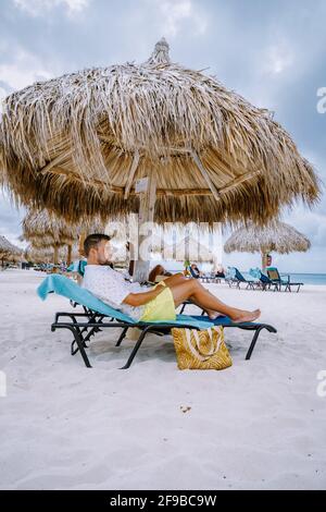 Aruba Caribbean coppia uomo e donna di mezza età in vacanza sulla spiaggia con palme sulla spiaggia Foto Stock