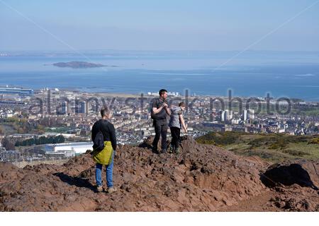 Edimburgo, Scozia, Regno Unito. 17 Aprile 2021. Il primo fine settimana completo di limitazioni di viaggio in tutta la Scozia, le persone si affollano nei soliti punti di interesse per i visitatori per godersi il sole e la vita all'aperto a Holyrood Park. Ammira la vista sul Forth Estuary e sull'isola di Inchkeith dalla cima di Arthurs Seat. Credit: Craig Brown/Alamy Live News Foto Stock