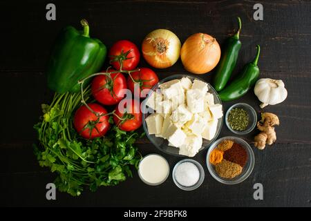 Ingredienti con sugo di Kadai Paneer: Formaggio paneer, verdure e spezie utilizzati per preparare un piatto tradizionale vegetariano indiano Foto Stock