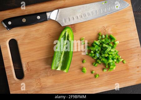 Peperoncino sminuzzato Jalapeño su un tagliere: Peperoncino verde sminuzzato su un tagliere di legno Foto Stock