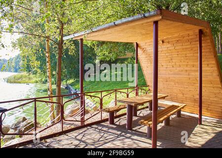 Gazebo in legno con tetto sulla riva del lago Foto Stock