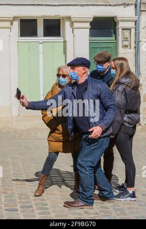 Gruppo di persone in strada con l'uomo che scatta foto al telefono - Loches, Indre-et-Loire, Francia. Foto Stock