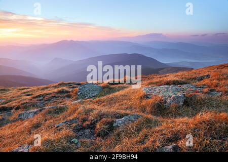 Panorama con interessante alba illumina i dintorni. Paesaggio con belle montagne e pietre. Fantastico paesaggio rurale d'autunno. Turistica re Foto Stock