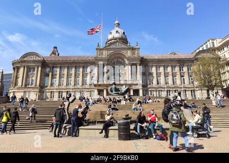 Centro di Birmingham, Regno Unito. 17 aprile 2021. Gli acquirenti e i festaioli sedevano sulle panchine fuori dalla Birmingham Council House con la Union Flag che volava a mezz'asta dopo la morte del principe Filippo. I visitatori hanno approfittato del bel tempo nel centro di Birmingham per godersi il "Super Saturday". Migliaia di persone sono uscite nonostante il funerale del principe Filippo che si è svolto oggi. I pub e i bar erano pieni e le strade erano un mare di gente. Fig. Per credito: Interrompi stampa Media/Alamy Live News Foto Stock