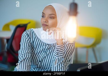 Giovane donna d'affari afro-americana musulmana come leader sul lavoro. Lavoro di squadra e concetto multietnico Foto Stock