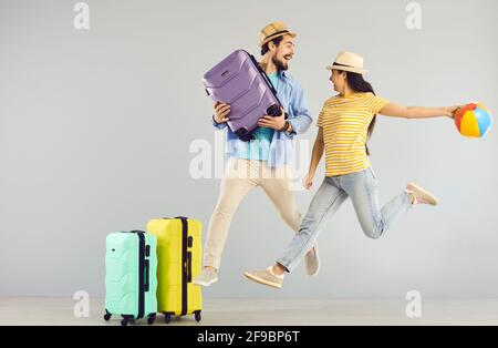Felice giovane coppia saltando e divertendosi eccitato circa il loro vacanza estiva viaggio Foto Stock