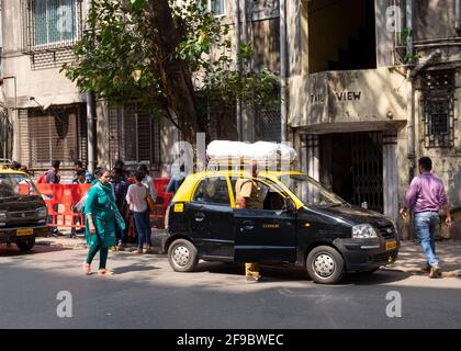 Taxi con borse sul portapacchi che fermano di fronte al vecchio edificio di appartamenti a Mumbai-Dadar, Maharashtra, India, Asia. Foto Stock