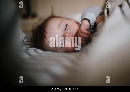 Ragazzo neonato addormentato con capelli marroni in pace Co-Sleeping Foto Stock