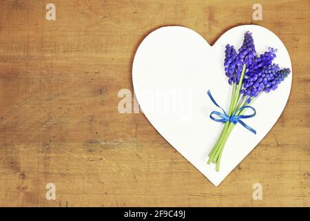 Madri giorno fiori e cuore su sfondo di legno Foto Stock