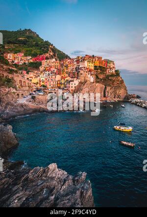 Manarola village sulla scogliera di rocce e mare al tramonto., Seascape in cinque terre, il Parco Nazionale delle Cinque Terre Liguria Italia Europa. Foto Stock