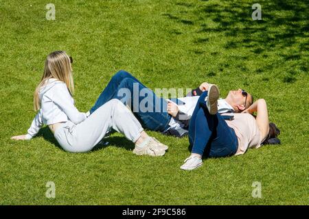 Bath, Somerset, Regno Unito. 17 aprile 2021. Il primo sabato dopo che il soggiorno di Covid a casa le restrizioni sono state tolte in Inghilterra, la gente è pictured godendo il sole in Parade Gardens. Credit: Lynchpics/Alamy Live News Foto Stock