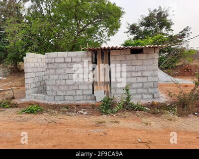 Closeup di una casa semi-costruita con blocco di cemento a un campo vuoto in campagna Foto Stock